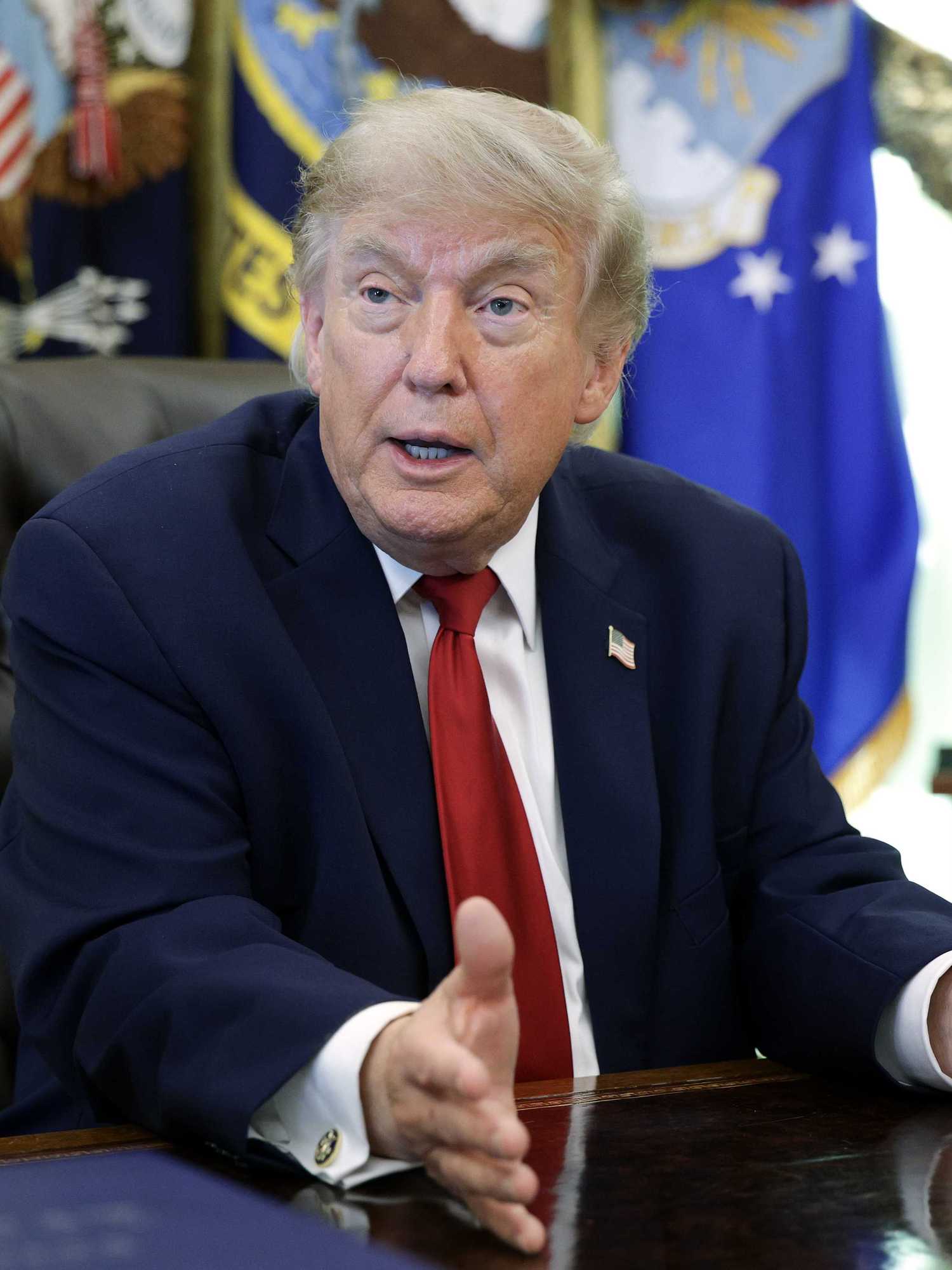 Donald Trump talks to reporters in the Oval Office.