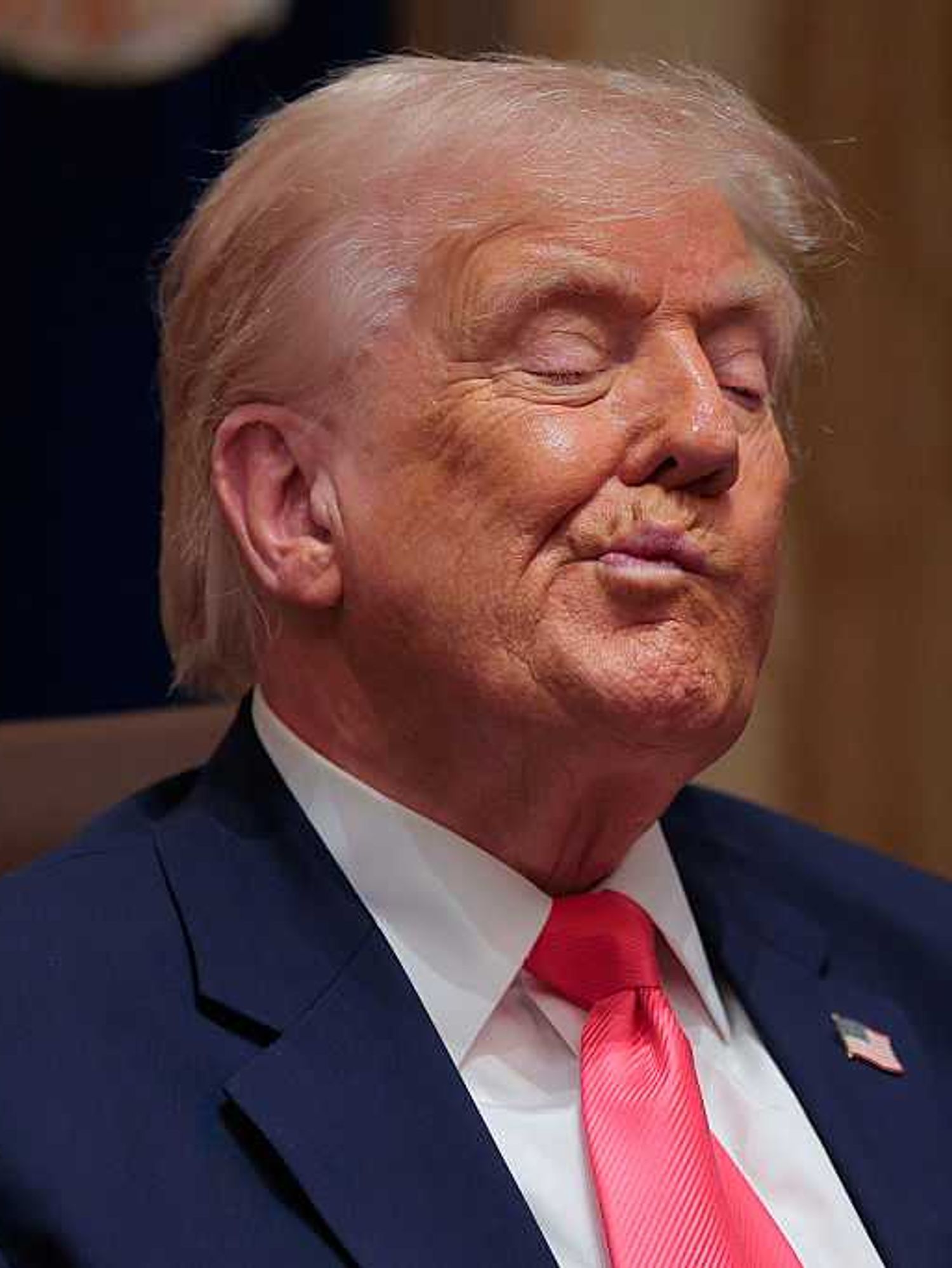 Donald Trump twists his mouth while listening to officials at a cabinet meeting.