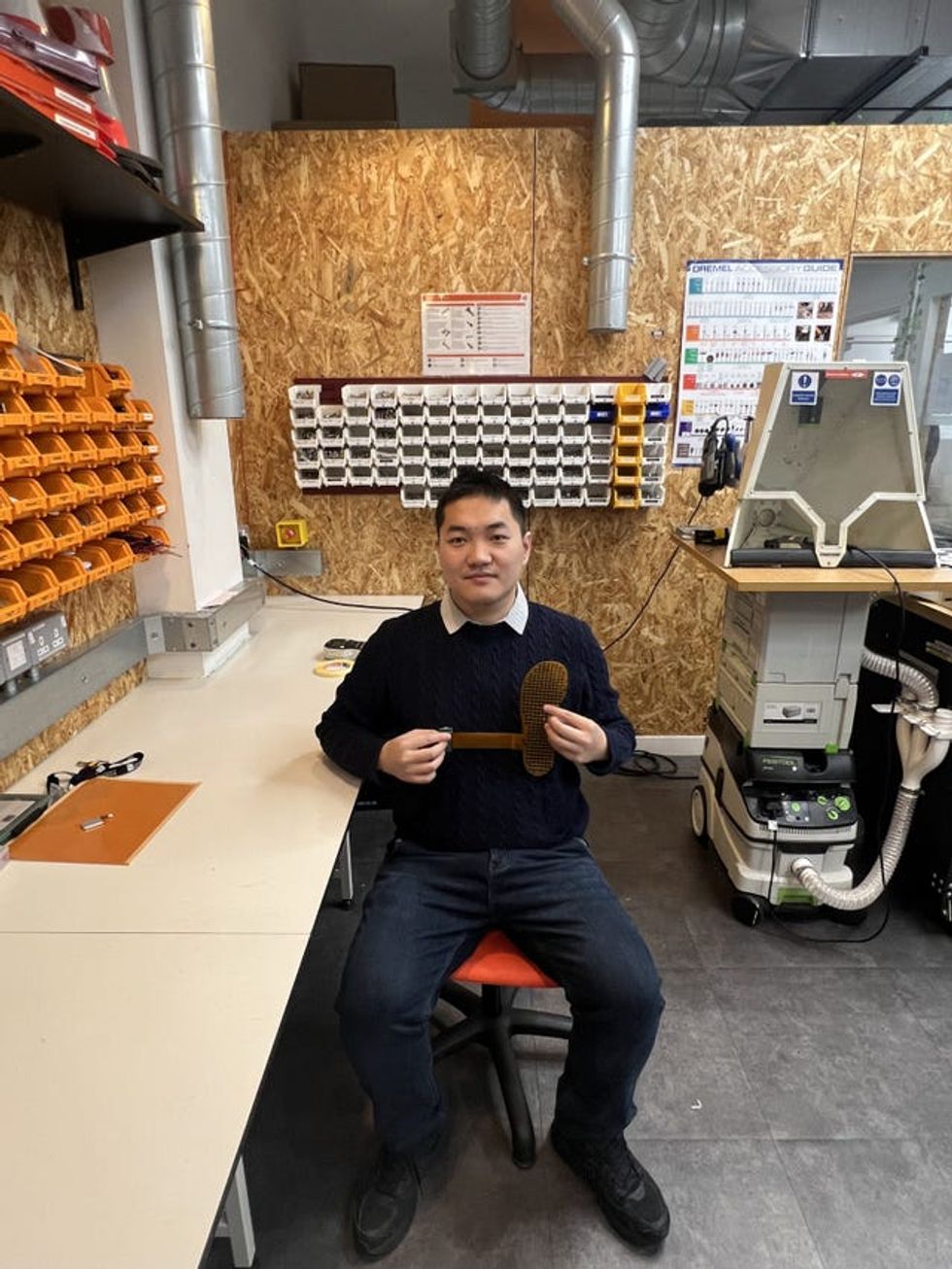 Dr Jiayang Li holding an ingenious insole, which features hundreds of sensors to read a person\u2019s gait