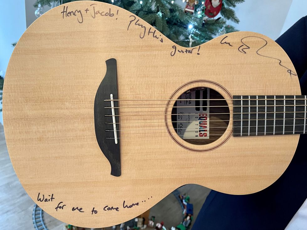 Ed Sheeran wrote \u2018Henry + Jacob! Play this guitar!\u2019 on the instrument, personalising it for the charity raffle winners. (GeeWizz/ PA)