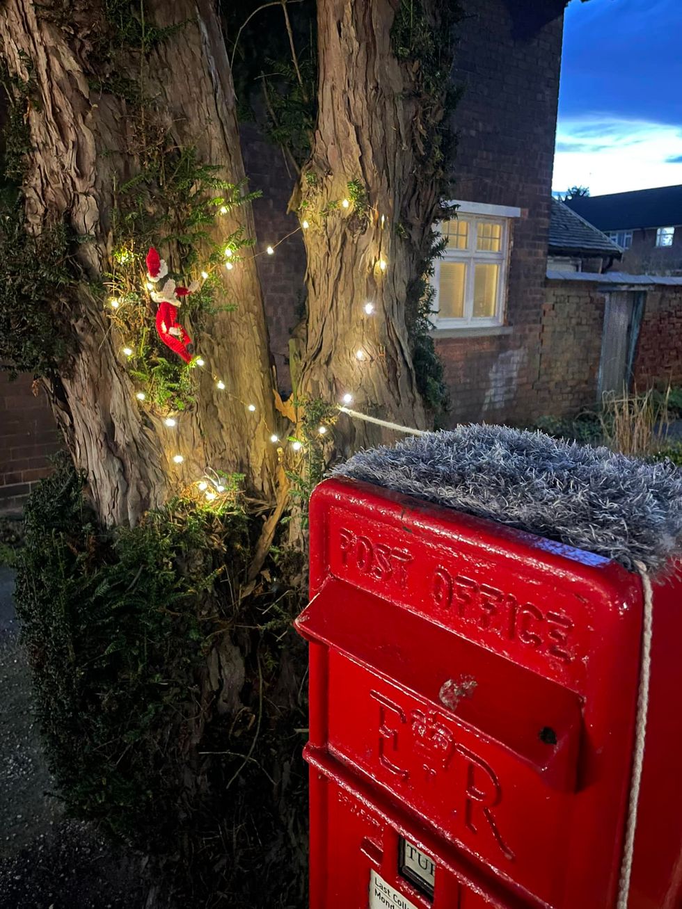 Elf decorating tree with lights