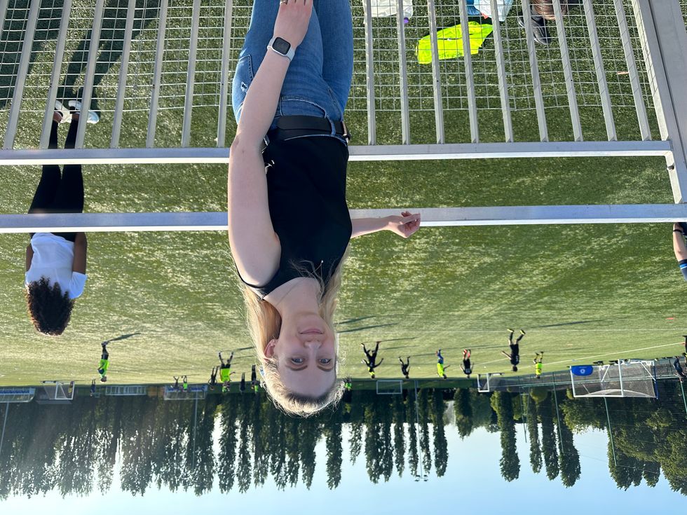 Ellie Vesey-Thompson standing in front of a football pitch