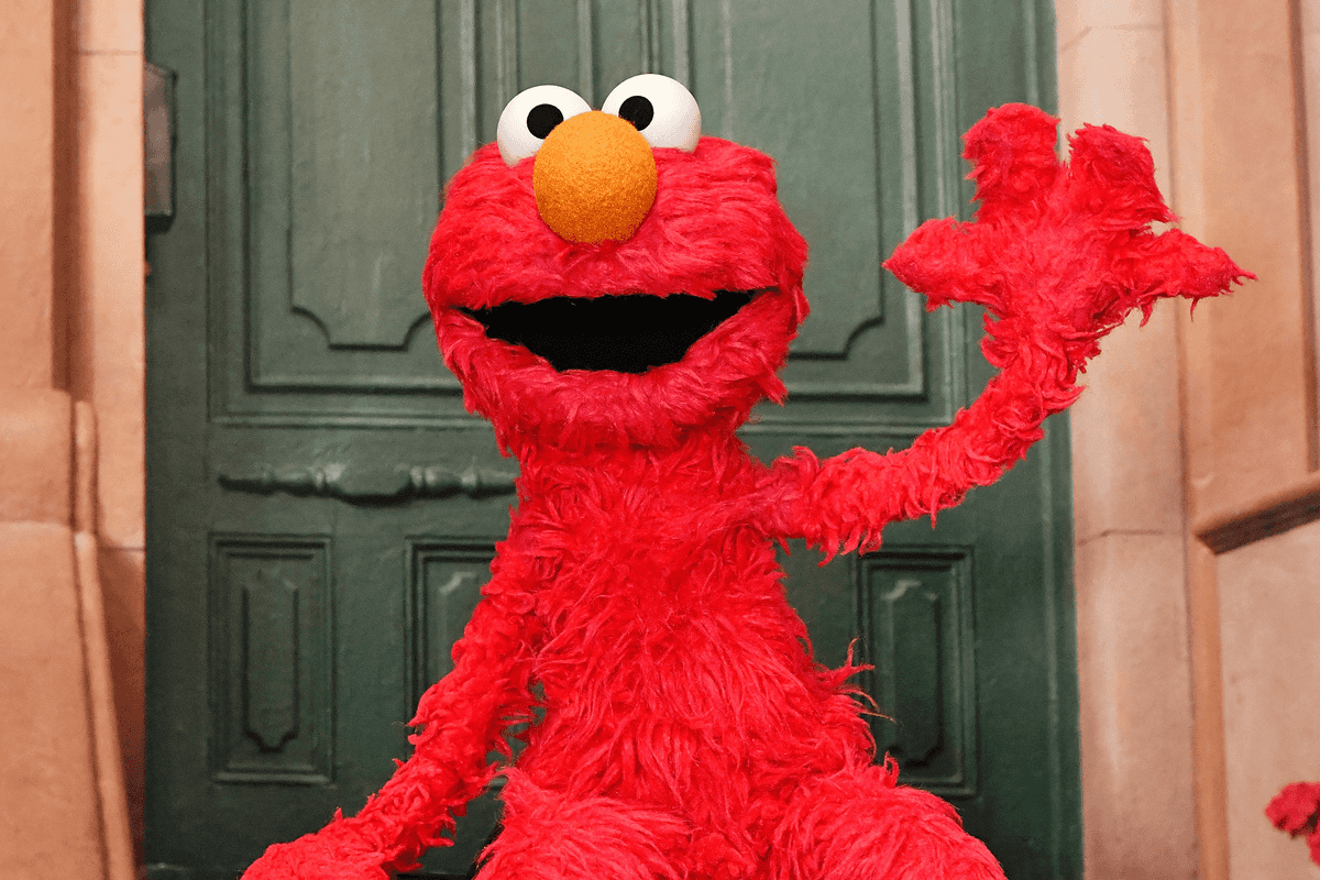 Elmo waves on the set of Sesame Street.