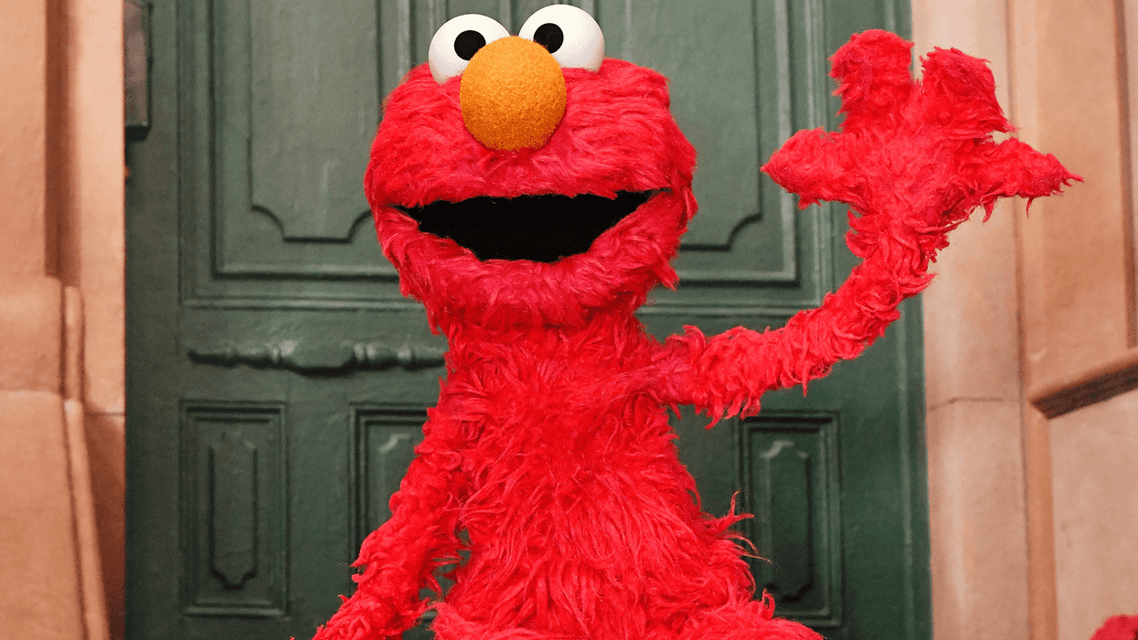 Elmo waves on the set of Sesame Street.