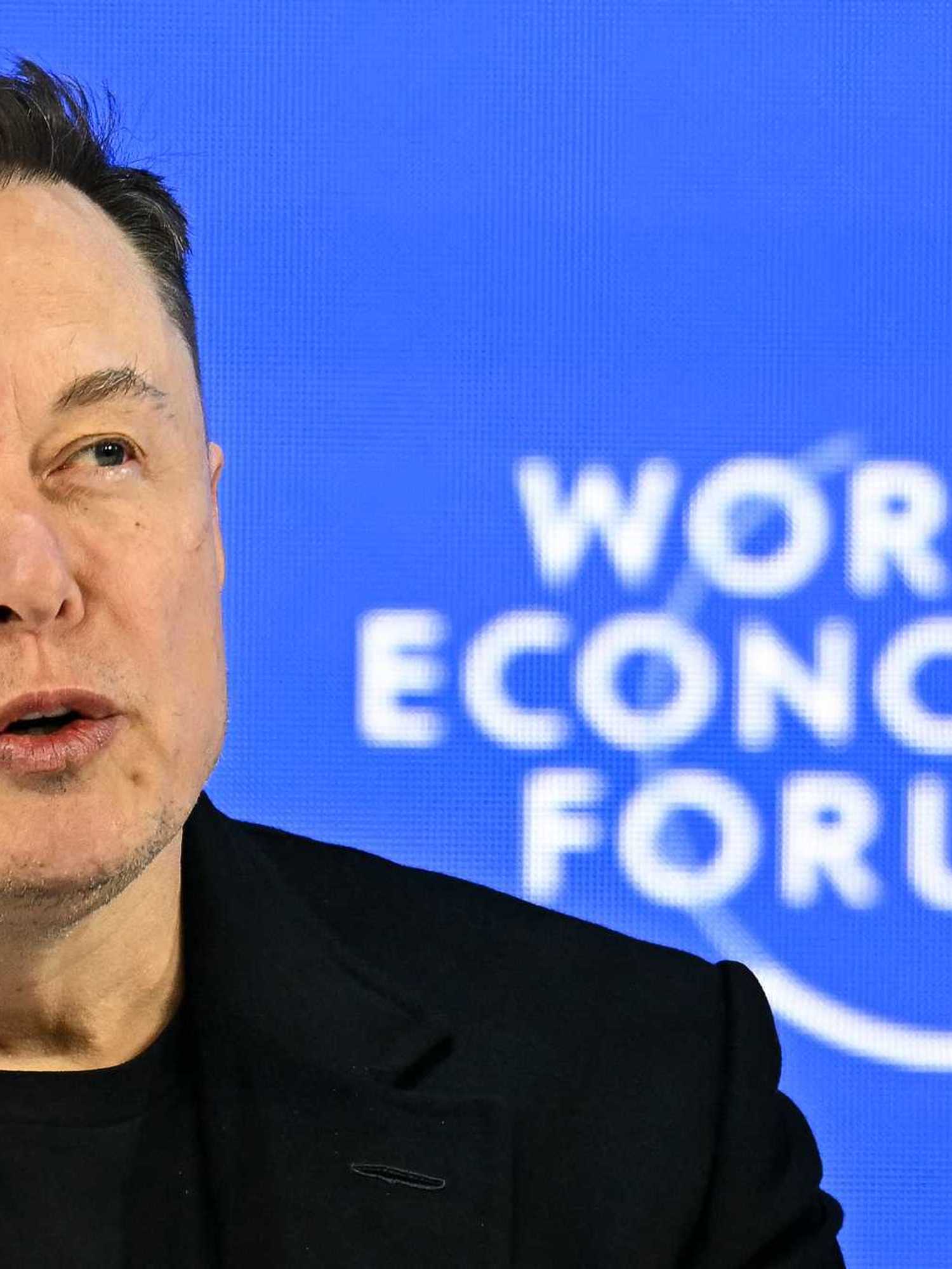 Elon Musk, a white man with sort black hair, speaking at the World Economic Forum.