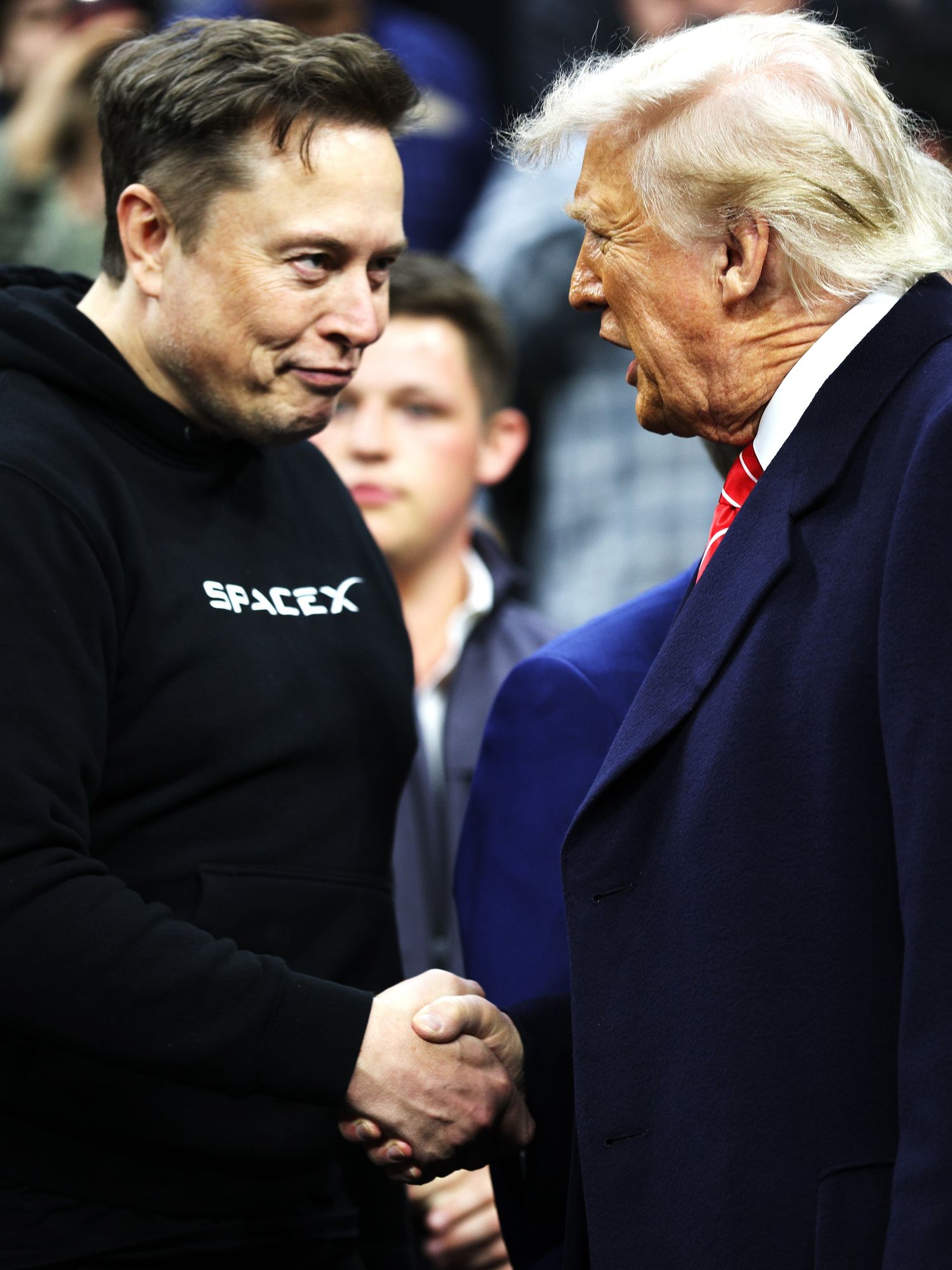 Elon Musk (left) and Donald Trump (right) shake hands while attending the NCAA Division I Wrestling Championship in Philadelphia, Pennsylvania.