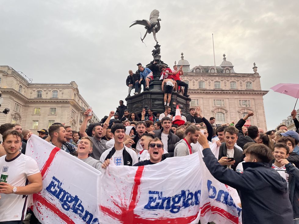 England football fans climb the statue of Eros in Piccadilly Circus, central London, celebrating England\u2019s victory over Germany in the Euro 2020 round of 16 match. Picture date: Tuesday June 29, 2021