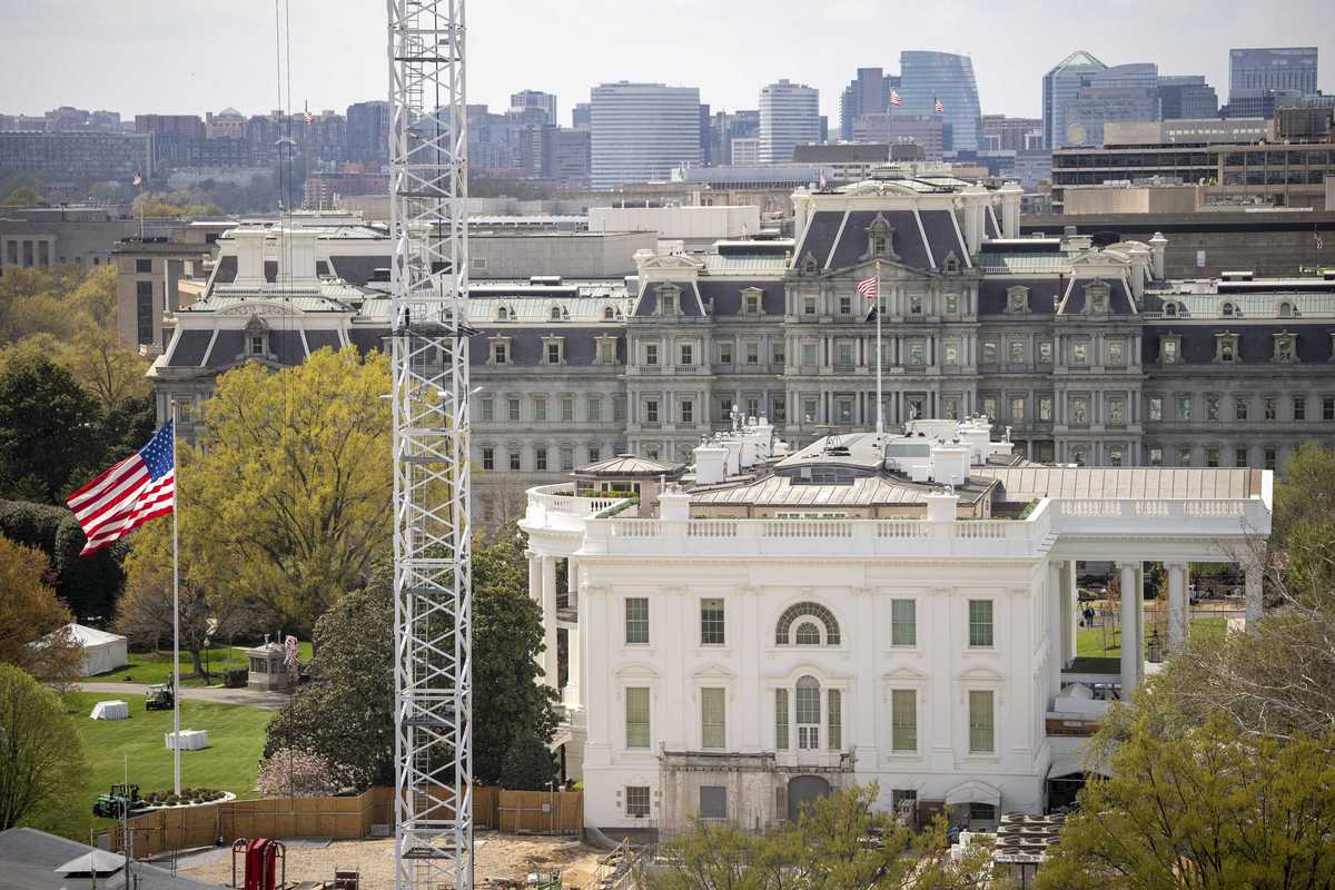 Exterior of the White House with a giant crane to the left of it.
