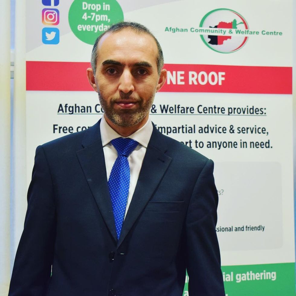 Fahim Zazai standing in front of a poster with details about the Afghan Community and Welfare Centre on it (Fahim Zazai/PA).