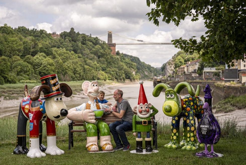 Father and son Adam and Freddie Hine-Haycock, 6, greet Wallace & Gromit sculptures unveiled as part of the Gromit Unleashed 2025 trail in Bristol