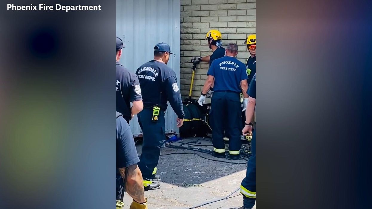 Firefighters rescue man trapped between a building and a shipping container