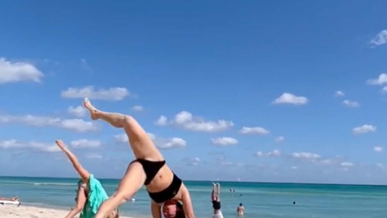 Woman interrupted while doing bikini yoga on beach - by cute kid who asked to join in