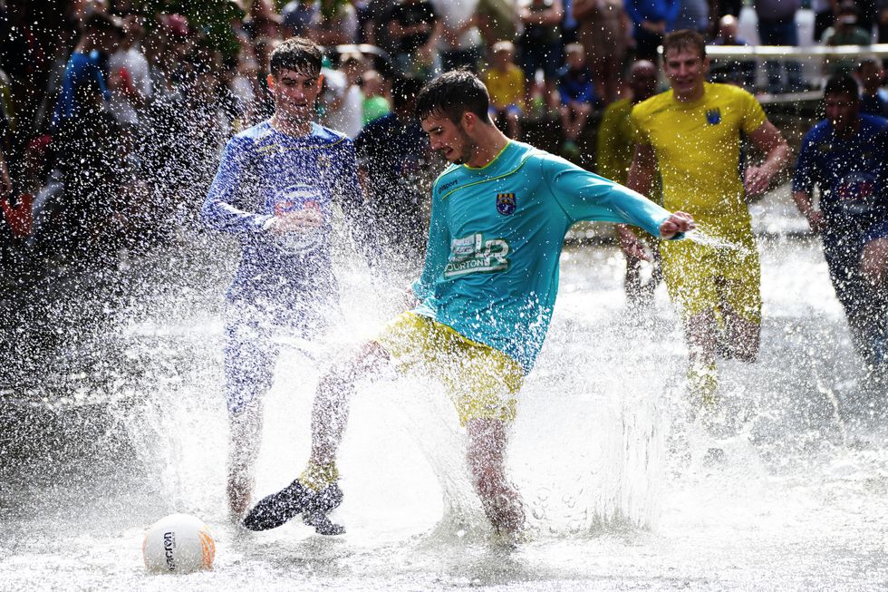 Annual river football clash goes ahead despite waterlogged pitch