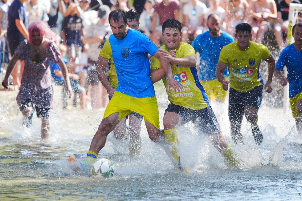Annual river football clash goes ahead despite waterlogged pitch