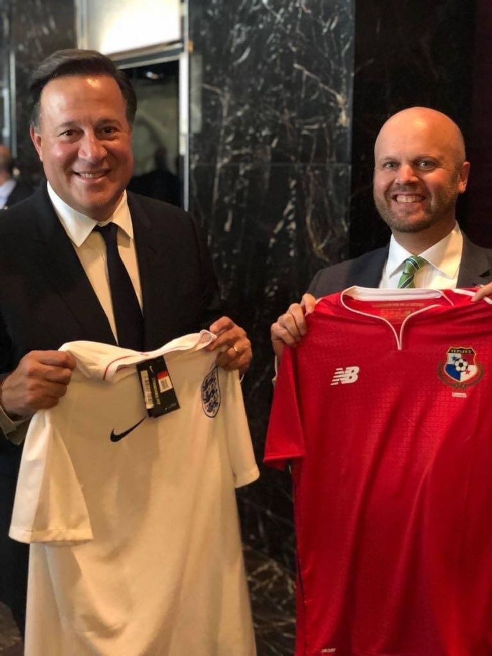 Former British diplomat Damion Potter poses with the Panamanian President holding panama and England shirts