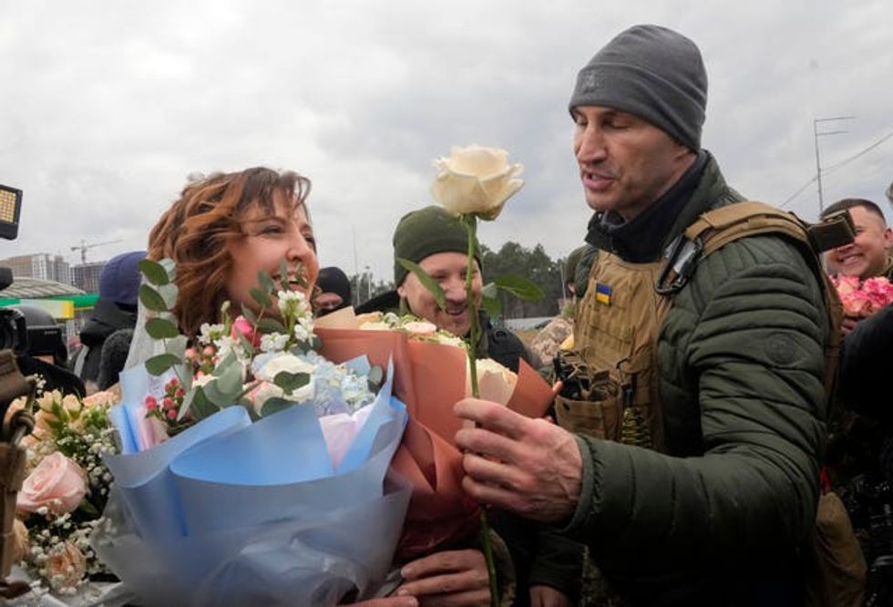 Former Ukrainian heavyweight boxing world champion Wladimir Klitschko, right, congratulates newly married members of the Ukrainian Territorial Defence Forces Lesia Ivashchenko, left, and Valerii Fylymonov