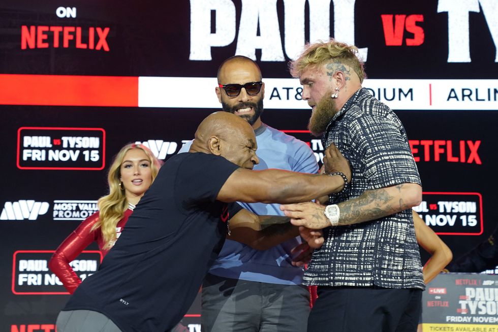 Former US heavyweight boxing champion Mike Tyson and US YouTuber and boxer Jake Paul face off during a press conference at Fanatics Fest NYC on August 18, 2024, in New York City