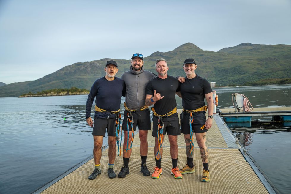 Four rowers stading on a jetty
