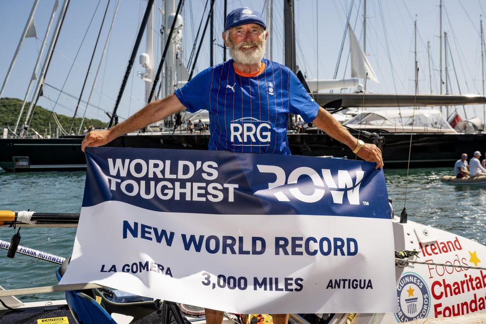 Frank Rothwell holding up a banner reading New World Record