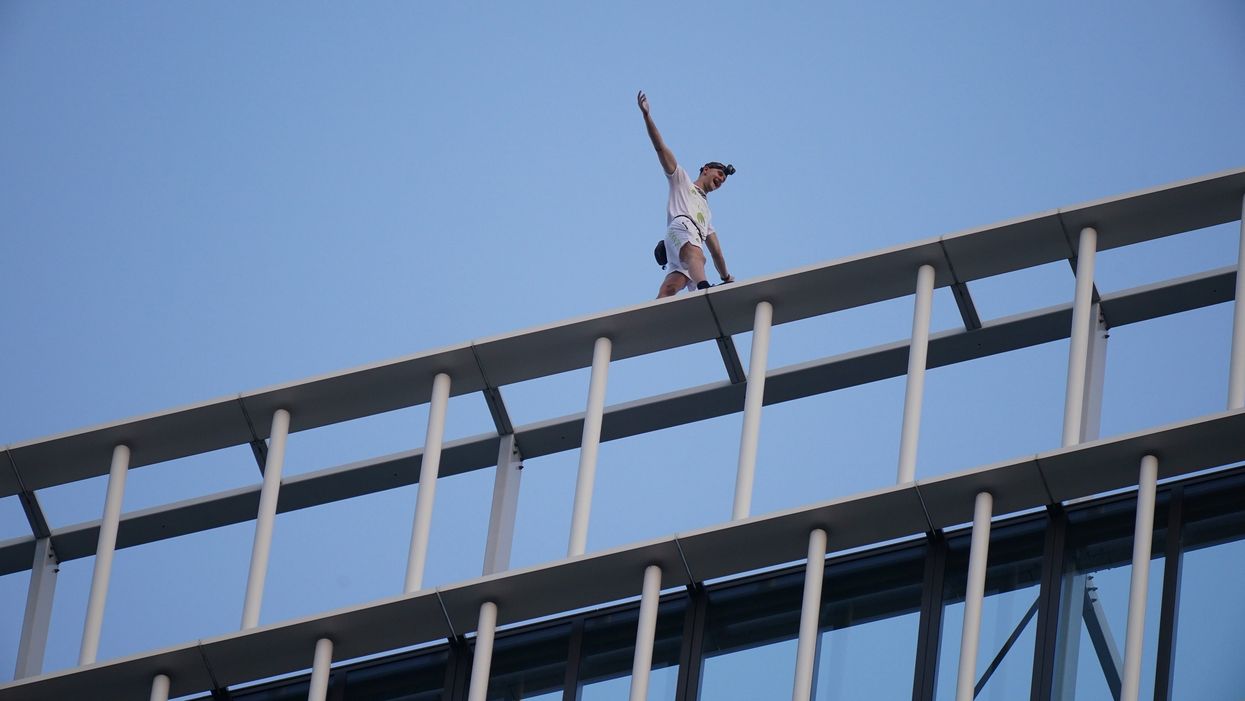 Free-solo climber George King-Thompson walks along the top of the Stratosphere Tower building, a 36-storey residential tower block in Stratford, east London (PA)