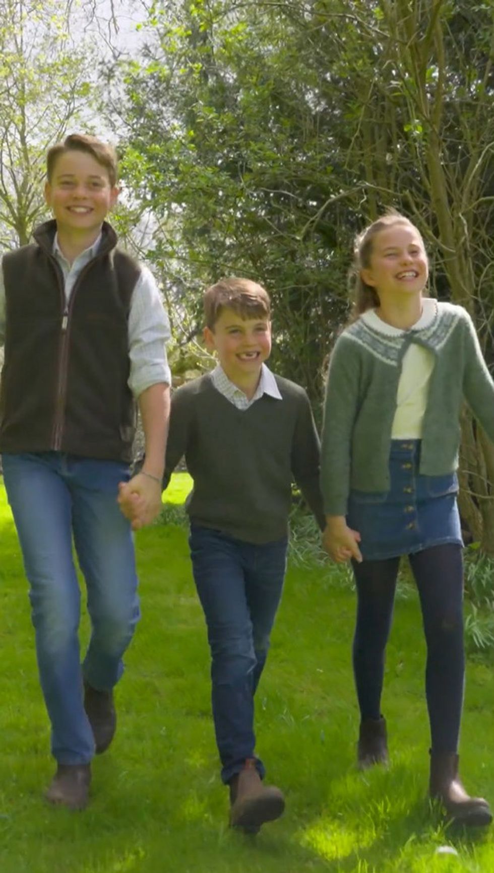 George, Louis and Charlotte walking and holding hands during a photoshoot
