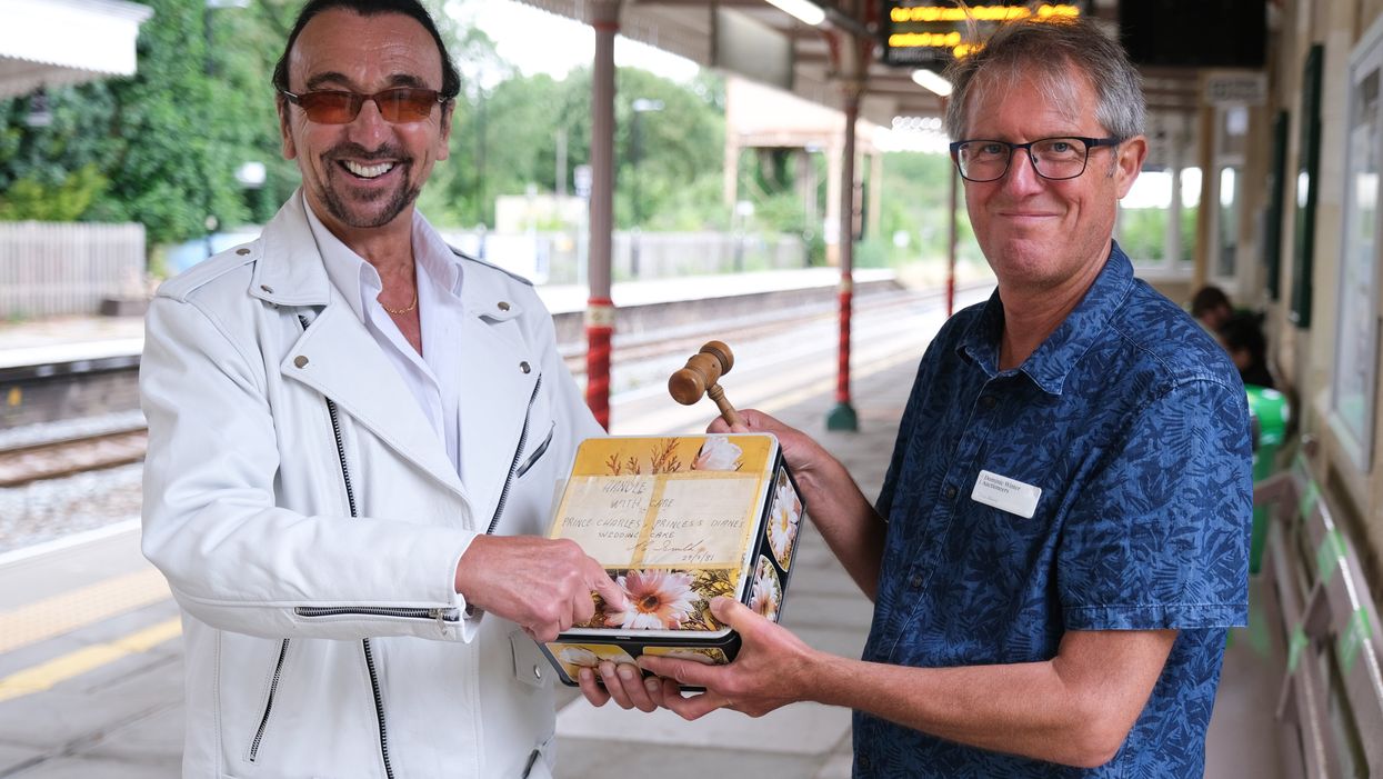 Gerry Layton (left) collects his £1,850 slice of Charles and Diana’s wedding cake from Chris Albury (Dominic Winter Auctioneers/PA)