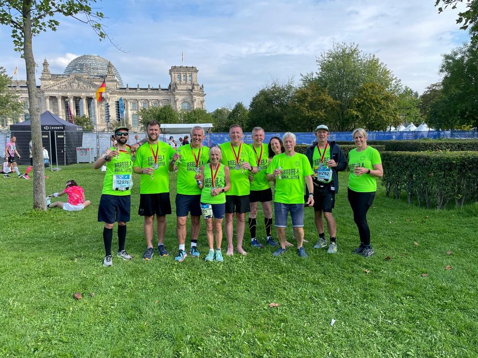 Gina Little celebrates her 600th marathon with friends from Plumstead Runners, in front of the Reichstag in Berlin