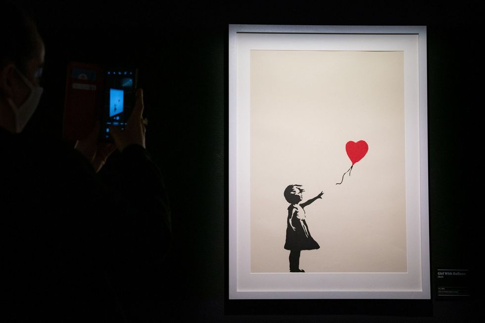 Girl With Balloon was one of Banksy\u2019s best-known works before he partially shredded it and it was renamed Love Is In The Bin (Aaron Chown/PA)
