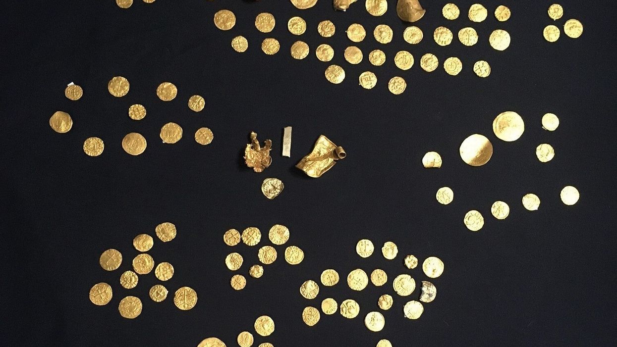 Gold coins, along with four other gold objects, unearthed by metal detectorists which is the largest hoard of Anglo-Saxon gold coins to be discovered in England to date (British Museum/PA)