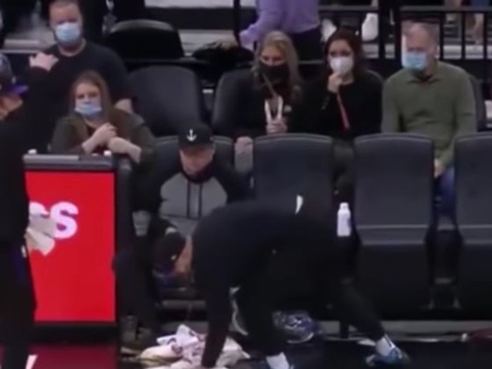Golden 1 Center staff  cleaning up the fan\u2019s vomit as he sits there.
