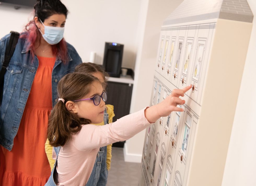GOSH patient Iona at the interactive way-finding doll\u2019s house in GOSH\u2019s Sight and Sound Centre supported by Premier Inn