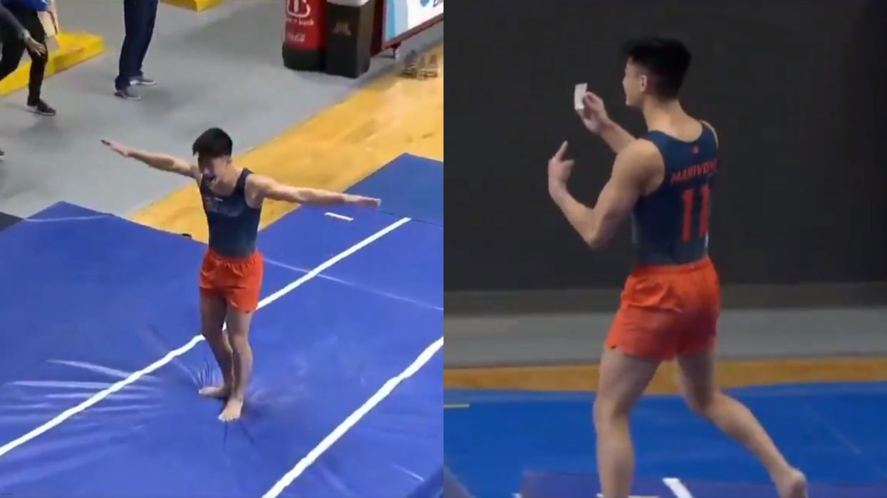 Gymnast Evan Manivong celebrates by brandishing his vaccination card