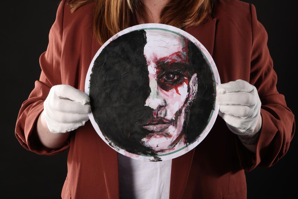 Hands holding a circular Johnny Depp painting