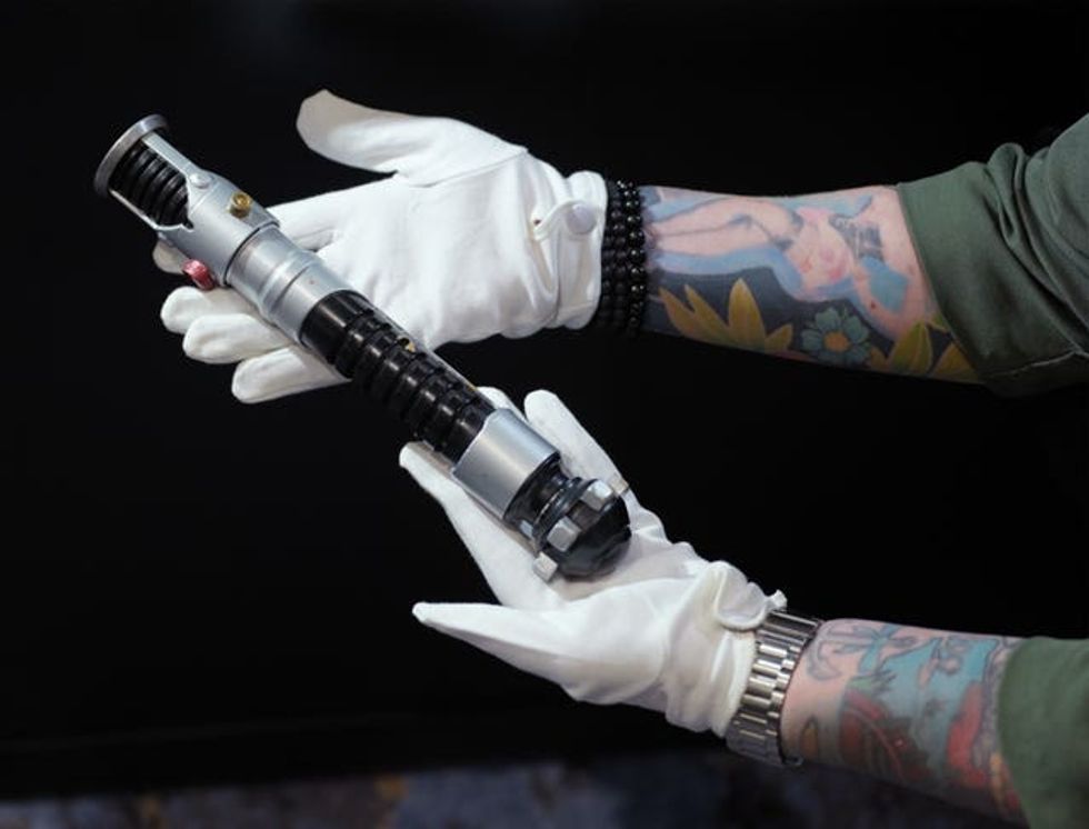 Hands holding a lightsaber