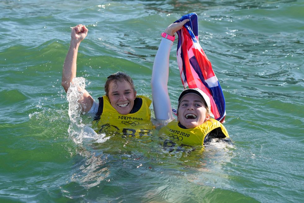 Hannah Mills and Eilidh McIntyre celebrate their golds in the sea (Gregorio Borgia/AP)
