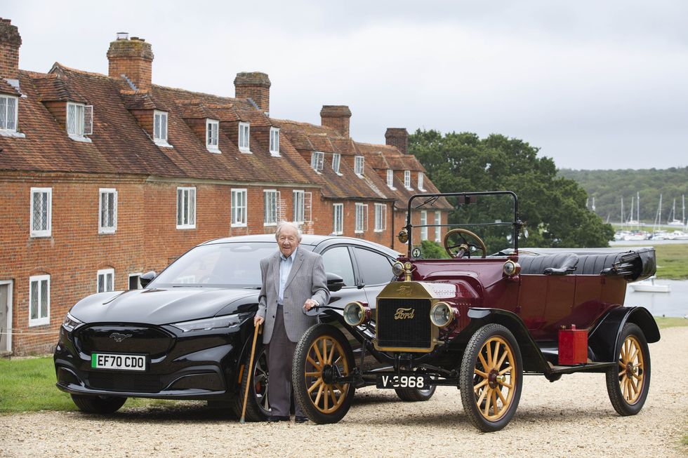 Harold Baggott stands alongside the new Mustang Mach-E and a Model T from 1915 (Matt Alexander/PA)