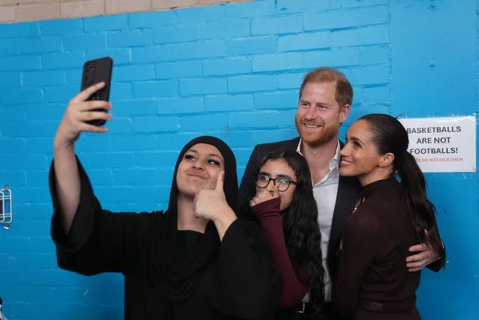 Harry and Meghan pose for a selfie at Epic Partners
