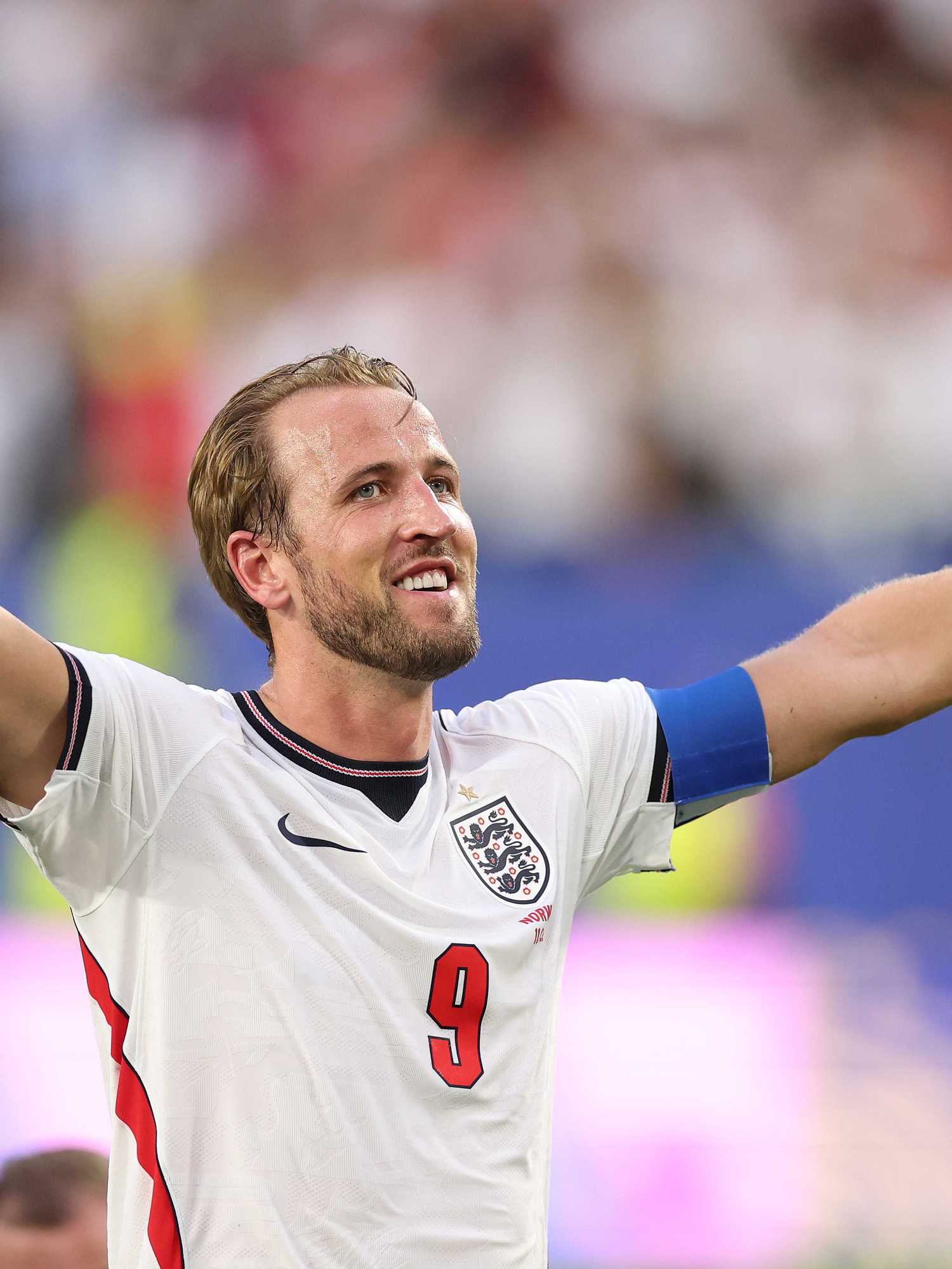 Harry Kane raises his hands in celebration during an England football match.