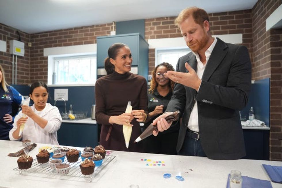 Harry licks icing from his hand during the visit to Epic Partners