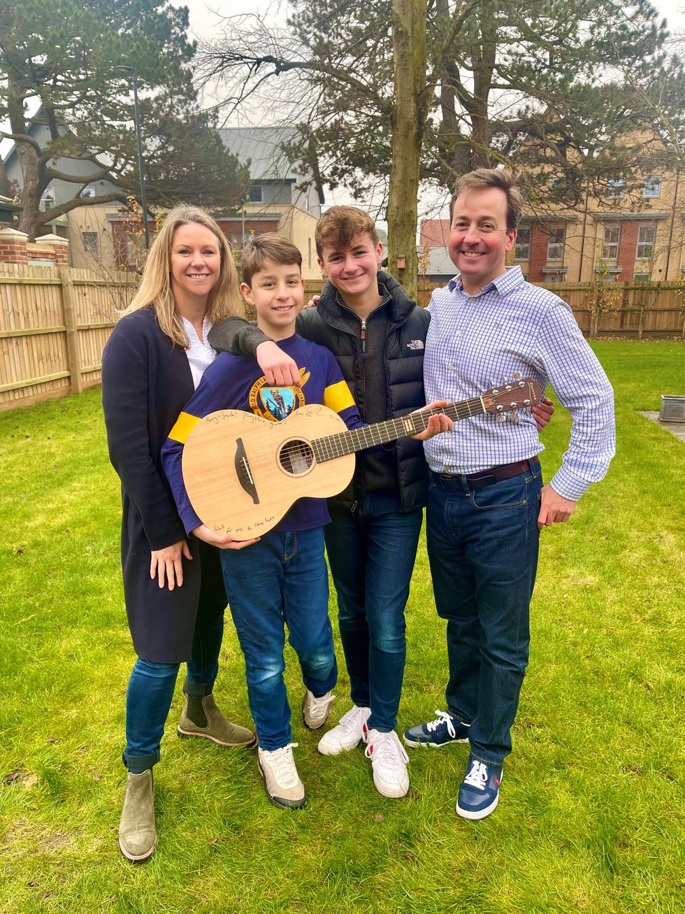 Hospital worker Kellie Myers and her family with Ed Sheeran\u2019s prototype guitar, that they won through a charity raffle. (GeeWizz/ PA)