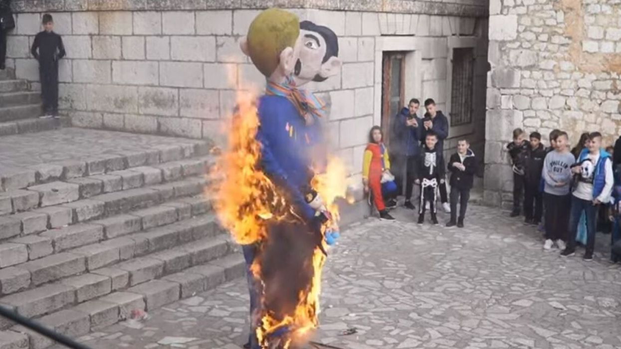 Festival burns effigy of gay dads holding a baby as crowd of onlookers cheer