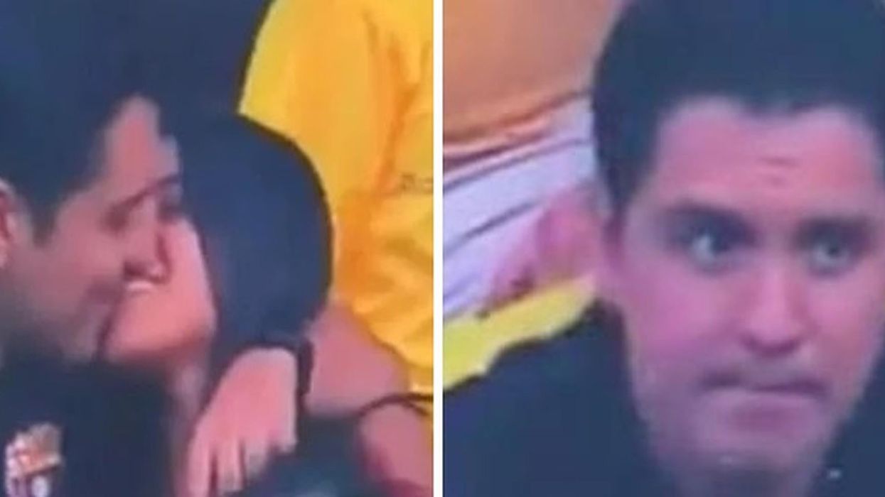 Football fan looks very guilty after being caught kissing woman on camera at match