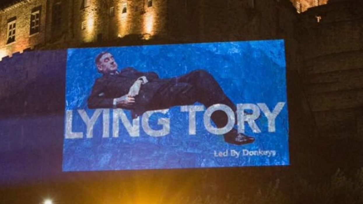 Image of Jacob Rees-Mogg lying down in Commons projected onto Edinburgh Castle