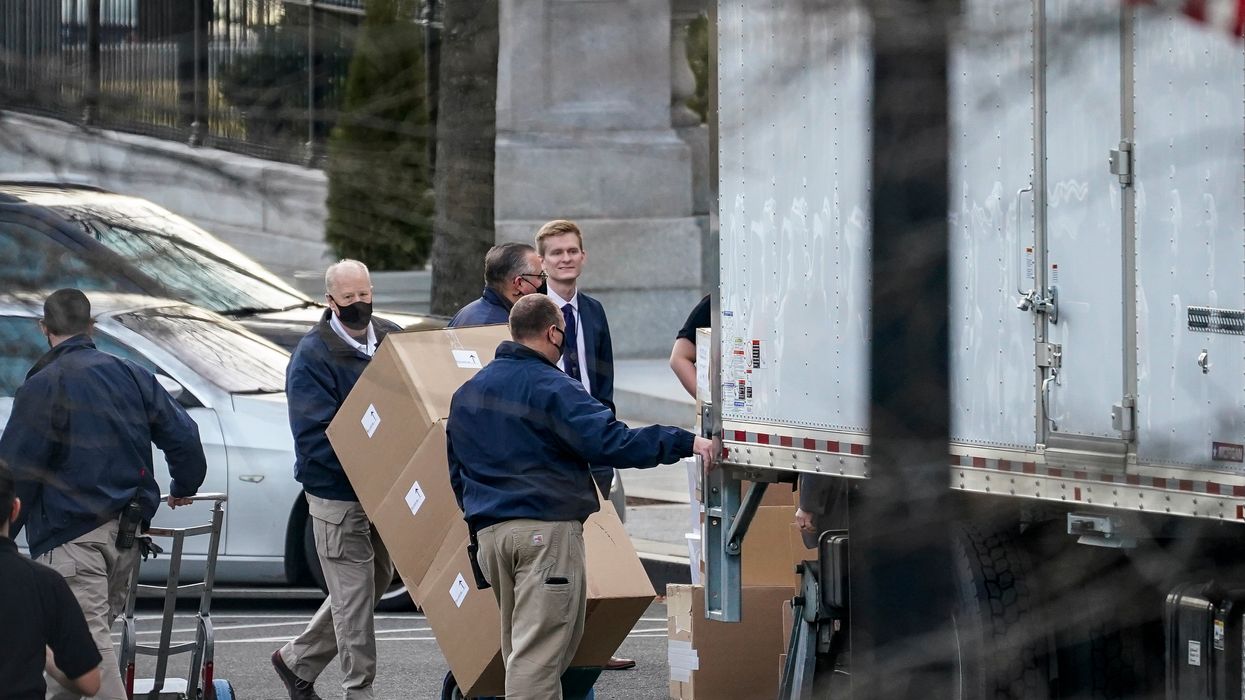 People celebrate as moving trucks for Trump are spotted outside of the White House