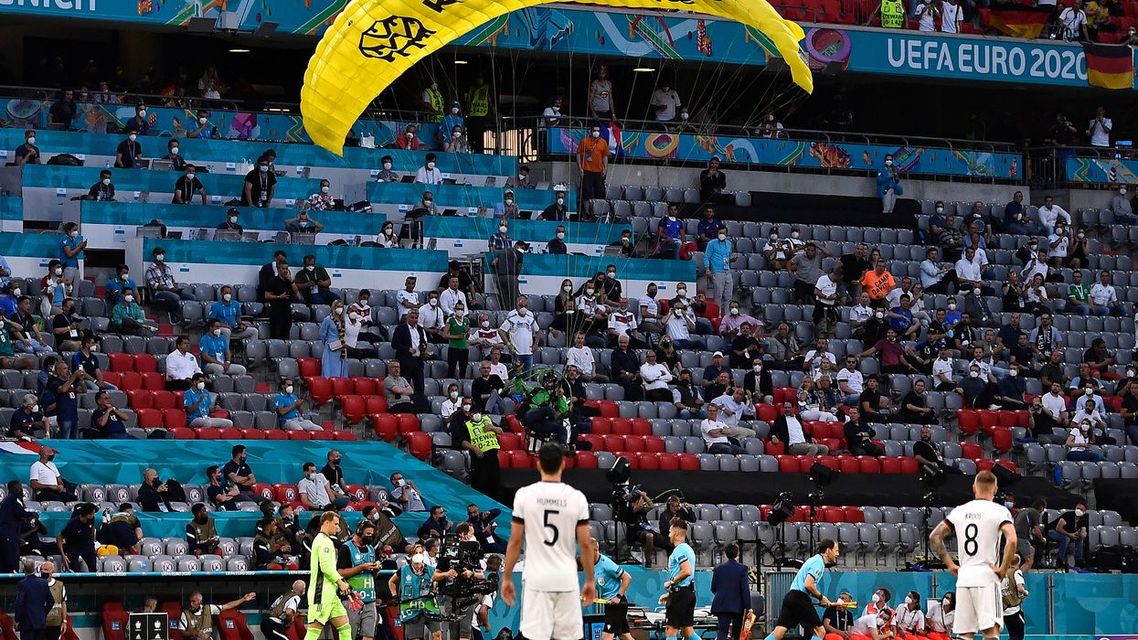 Greenpeace protester gets tangled in aerial camera while parachuting into Euro 2020 stadium