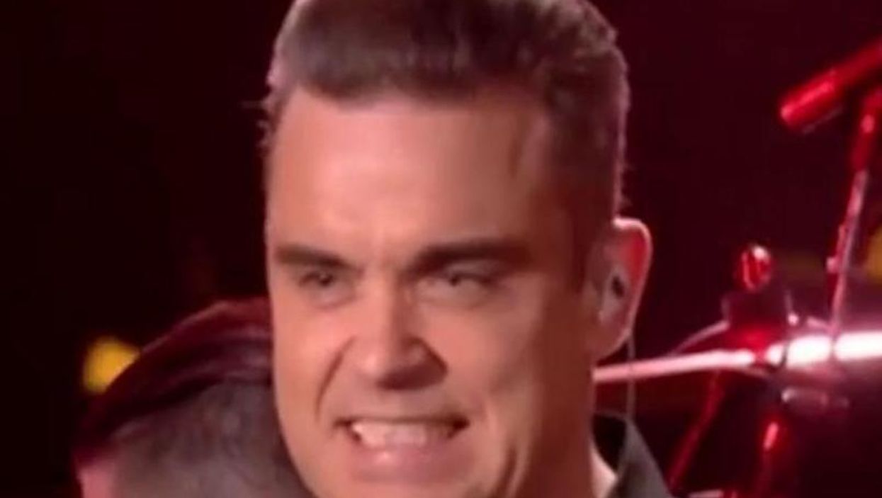Robbie Williams high-fives audience members, uses hand sanitiser immediately after