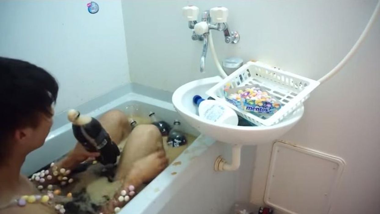 Man covered in mentos jumps into a bath of coke
