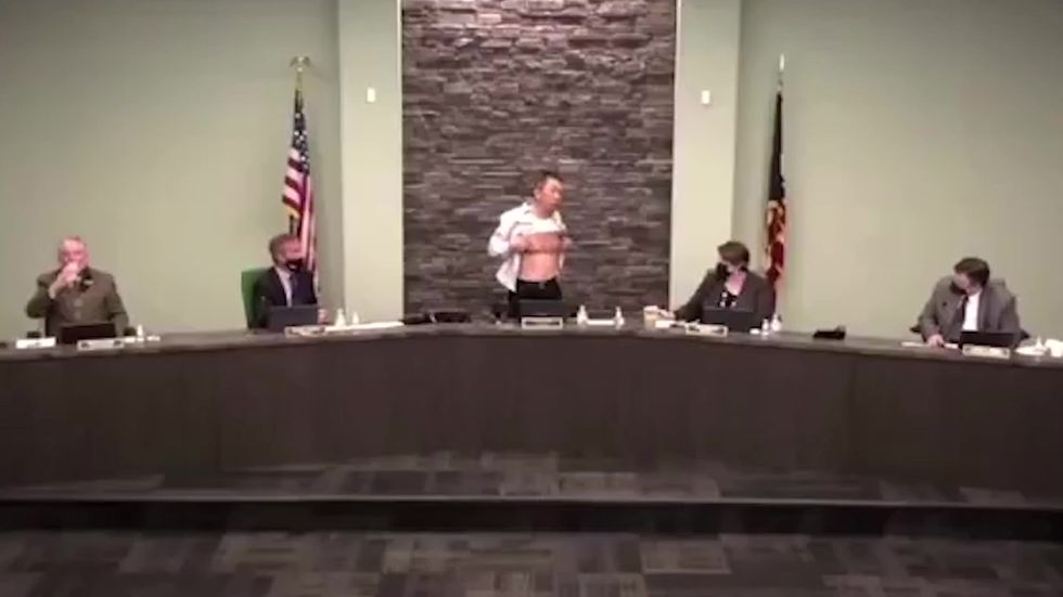Asian-American elected official Lee Wong takes off his shirt to reveal scars from US military service while discussing discrimination he's faced for being Asian