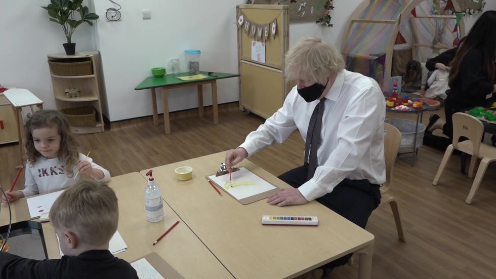 Boris ponders origin of kiwi fruit while painting banana during nursery visit