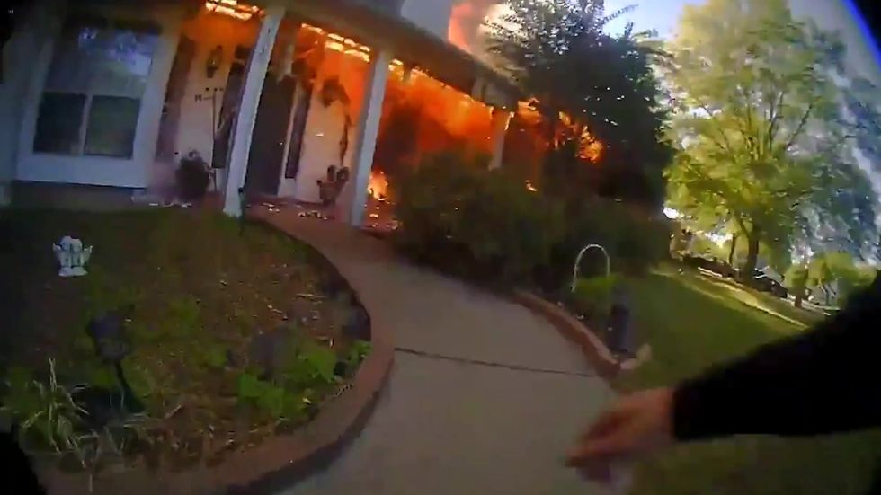 Police officer filmed rushing into a raging house fire to rescue a couple and their dog